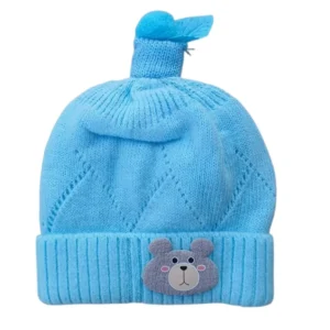 Sky blue knitted winter cap with teddy bear face and decorative blue topper