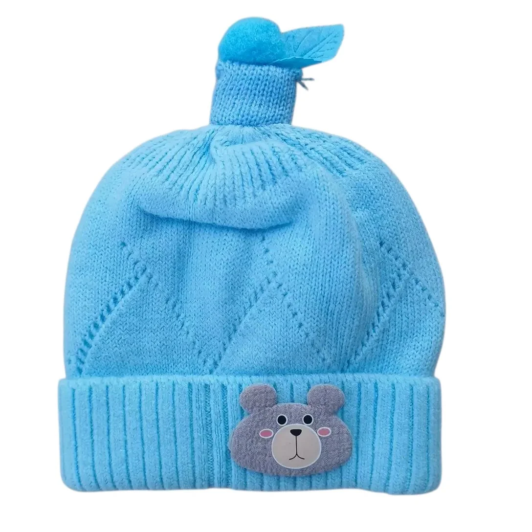 Sky blue knitted winter cap with teddy bear face and decorative blue topper